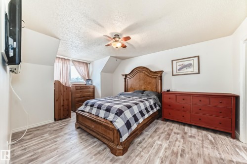Bedroom featuring a textured ceiling, light wood finished floors, and a ceiling fan - 18931 80 Avenue, Edmonton, AB - Indoor Photo Showing Bedroom