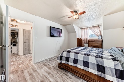 Bedroom with light wood-style floors, a textured ceiling, a ceiling fan, and lofted ceiling - 18931 80 Avenue, Edmonton, AB - Indoor Photo Showing Bedroom