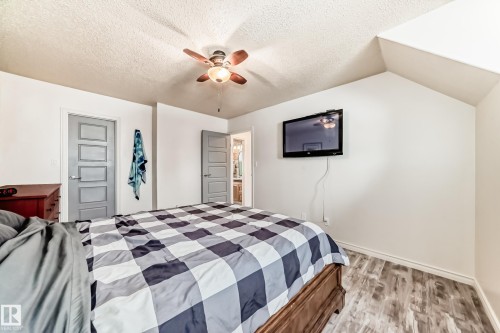 Bedroom with light wood-type flooring, ceiling fan, a textured ceiling, and vaulted ceiling - 18931 80 Avenue, Edmonton, AB - Indoor Photo Showing Bedroom