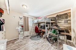 Bedroom with light wood-style flooring, an office area, and a textured ceiling - 
