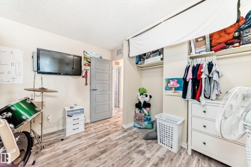 Bedroom with a closet, light wood-style floors, and a textured ceiling - 18931 80 Avenue, Edmonton, AB - Indoor