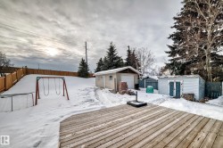 Snow covered deck featuring a fenced backyard and a shed - 
