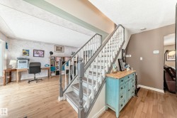 Staircase with hardwood / wood-style floors and a textured ceiling - 