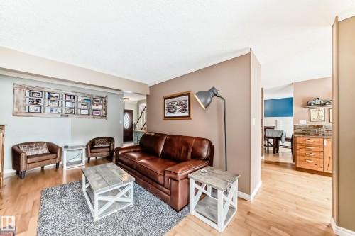 Living room featuring light wood-style flooring, stairs, and a textured ceiling - 18931 80 Avenue, Edmonton, AB - Indoor Photo Showing Living Room
