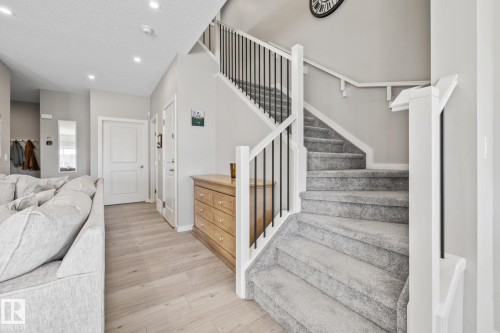 Stairs with wood finished floors, recessed lighting, and a textured ceiling - 217 Larch Crescent, Leduc, AB - Indoor Photo Showing Other Room