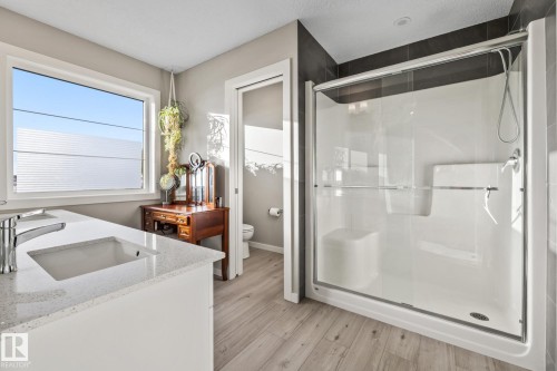 Full bathroom featuring a shower stall, double vanity, and light wood-style floors - 217 Larch Crescent, Leduc, AB - Indoor Photo Showing Bathroom