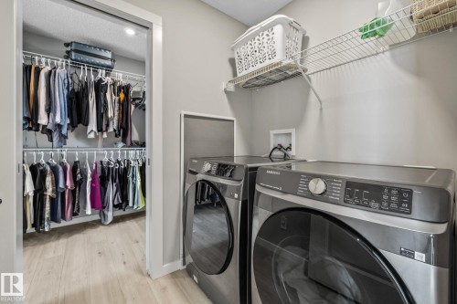Washroom featuring light wood-type flooring, washer and clothes dryer, and recessed lighting - 217 Larch Crescent, Leduc, AB - Indoor Photo Showing Laundry Room