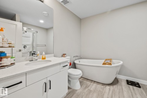 Bathroom with vanity, a freestanding tub, light wood-style floors, a shower stall, and recessed lighting - 217 Larch Crescent, Leduc, AB - Indoor Photo Showing Bathroom