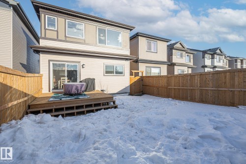 Snow covered rear of property featuring a residential view, a fenced backyard, and a deck - 217 Larch Crescent, Leduc, AB - Outdoor