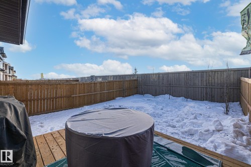 Yard layered in snow with a wooden deck and a fenced backyard - 217 Larch Crescent, Leduc, AB - Outdoor