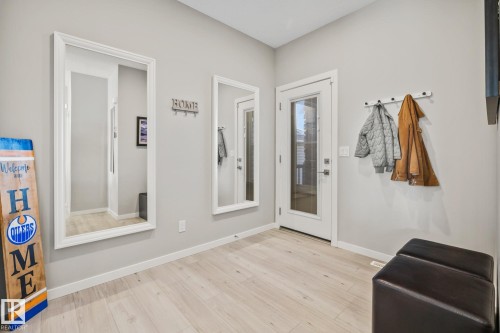 Foyer featuring baseboards and light wood finished floors - 217 Larch Crescent, Leduc, AB - Indoor Photo Showing Other Room