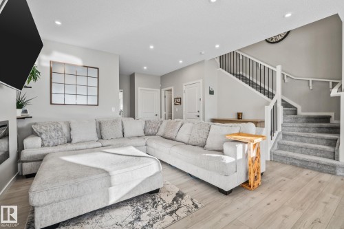 Living room featuring stairs, light wood-style flooring, and recessed lighting - 217 Larch Crescent, Leduc, AB - Indoor Photo Showing Living Room