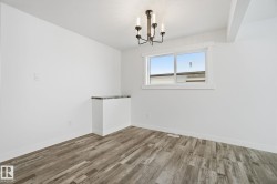 Spare room with a chandelier and wood finished floors - 