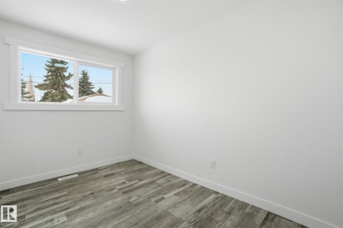 Empty room with wood finished floors and baseboards - 7112 132 Avenue, Edmonton, AB - Indoor Photo Showing Other Room