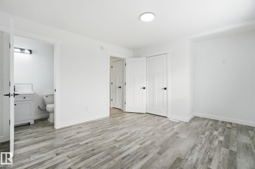 Unfurnished bedroom with a closet, light wood-style flooring, and ensuite bathroom - 7112 132 Avenue, Edmonton, AB - Indoor Photo Showing Other Room