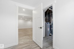Hall featuring light wood finished floors, electric water heater, and recessed lighting - 