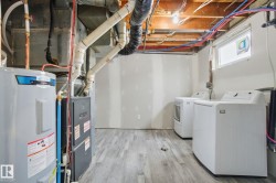 Laundry room with water heater, light wood finished floors, and washer and dryer - 