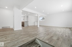 Below grade area with light wood-style flooring and recessed lighting - 