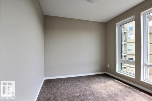 Unfurnished room featuring carpet flooring and baseboards - 125 1304 Rutherford Road, Edmonton, AB - Indoor Photo Showing Other Room