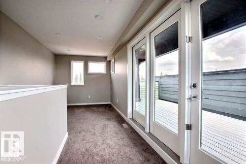 Carpeted spare room featuring baseboards - 125 1304 Rutherford Road, Edmonton, AB - Indoor Photo Showing Other Room