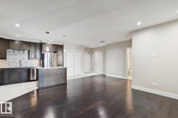 Kitchen with dark brown cabinetry, open floor plan, pendant lighting, appliances with stainless steel finishes, and a kitchen island - 