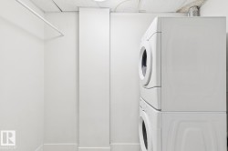 Laundry room with a paneled ceiling and stacked washing machine and dryer - 