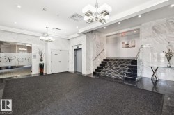 Unfurnished living room featuring a chandelier, elevator, stairs, recessed lighting, and granite floors - 