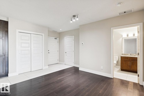 Unfurnished bedroom with ensuite bathroom, light wood finished floors, and a closet - 208 1350 Windermere Way, Edmonton, AB - Indoor Photo Showing Other Room