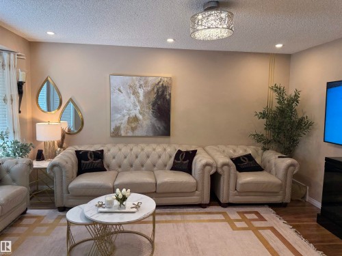Living area featuring a textured ceiling, wood finished floors, and recessed lighting - 11 15128 22 Street, Edmonton, AB - Indoor Photo Showing Living Room