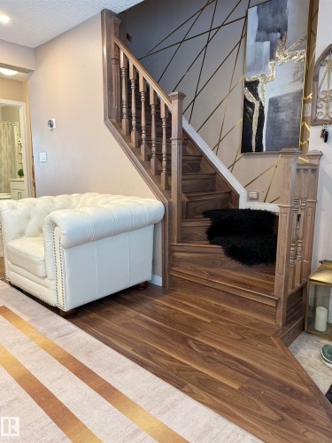 Staircase with wood finished floors and a textured ceiling - 11 15128 22 Street, Edmonton, AB - Indoor Photo Showing Other Room