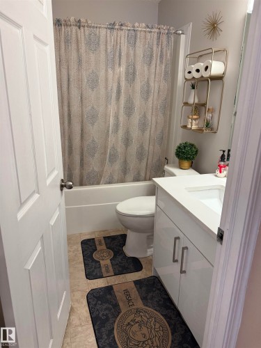 Bathroom featuring vanity and shower / bath combination with curtain - 11 15128 22 Street, Edmonton, AB - Indoor Photo Showing Bathroom