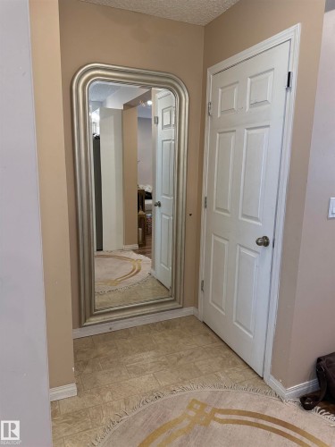 Corridor featuring a textured ceiling and baseboards - 11 15128 22 Street, Edmonton, AB - Indoor Photo Showing Other Room