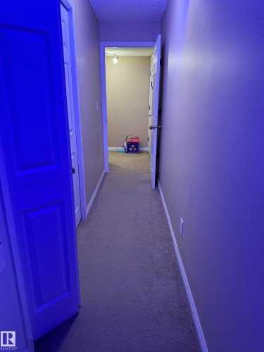 Hall featuring carpet and a textured ceiling - 11 15128 22 Street, Edmonton, AB - Indoor Photo Showing Other Room