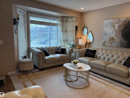 Living room with a textured ceiling and plenty of natural light - 11 15128 22 Street, Edmonton, AB - Indoor Photo Showing Living Room