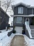 View of front of home featuring stucco siding, a garage, stairway, and a porch - 11 15128 22 Street, Edmonton, AB  - Outdoor 
