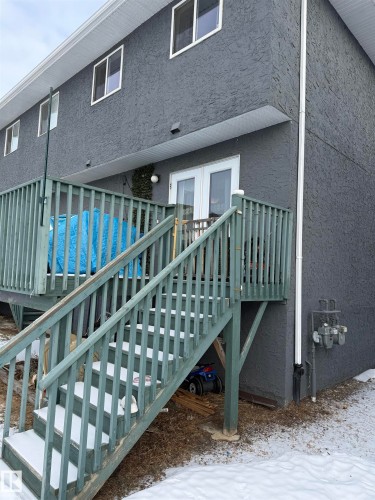 Exterior space featuring stucco siding, stairs, and french doors - 11 15128 22 Street, Edmonton, AB - Outdoor With Exterior