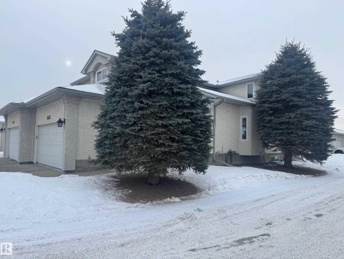 View of snowy exterior featuring stucco siding and a garage - 6562 158 Avenue, Edmonton, AB - Outdoor