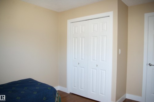Bedroom featuring a closet, a textured ceiling, and dark wood finished floors - 168 Warwick Road, Edmonton, AB - Indoor Photo Showing Bedroom