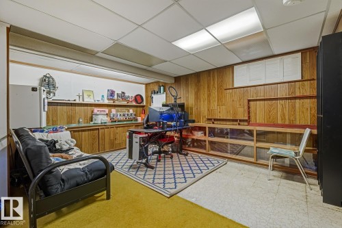 Office area featuring wooden walls, light flooring, and a paneled ceiling - 11516 152A Avenue, Edmonton, AB - Indoor