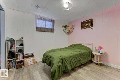 Bedroom with light wood finished floors and wood walls - 11516 152A Avenue, Edmonton, AB - Indoor Photo Showing Bedroom