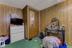 Carpeted bedroom featuring wood walls - 