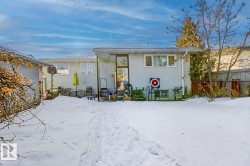 Snow covered back of property featuring stucco siding and a patio - 