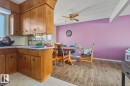 Kitchen with brown cabinets, light countertops, backsplash, ceiling fan, and beam ceiling - 11516 152A Avenue, Edmonton, AB  - Indoor Photo Showing Kitchen 