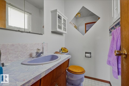 Half bathroom featuring vanity, light floors, and an AC wall unit - 11516 152A Avenue, Edmonton, AB - Indoor Photo Showing Bathroom