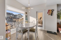 Dining area featuring light wood-style flooring and vaulted ceiling - 