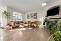 Living area featuring hardwood / wood-style floors, a textured ceiling, and a tile fireplace - 