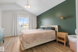 Bedroom with light wood finished floors and vaulted ceiling - 