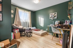 Bedroom featuring light wood-style flooring and a textured ceiling - 