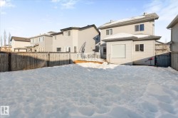 Snow covered property with a fenced backyard, a deck, and a residential view - 