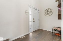 Foyer with wood-type flooring and baseboards - 